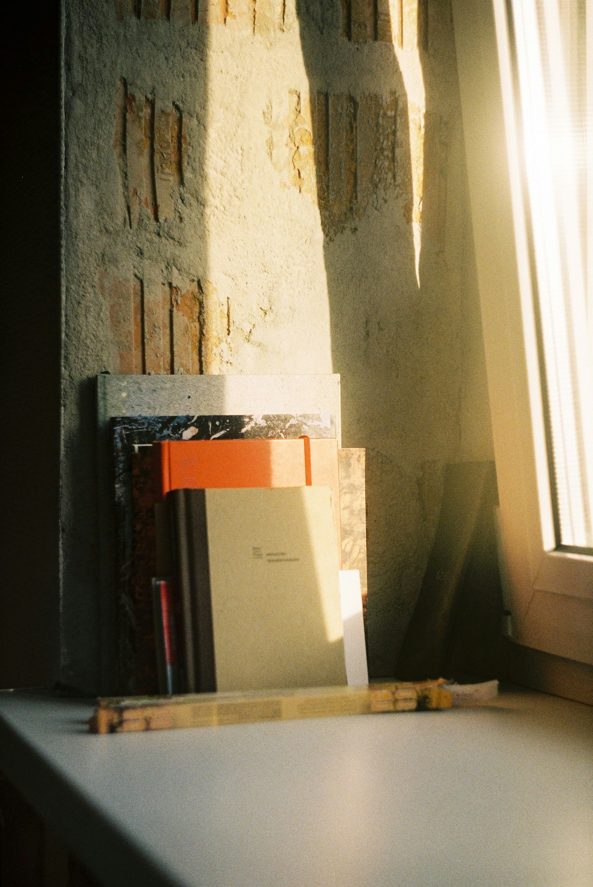 Books stacked in window light